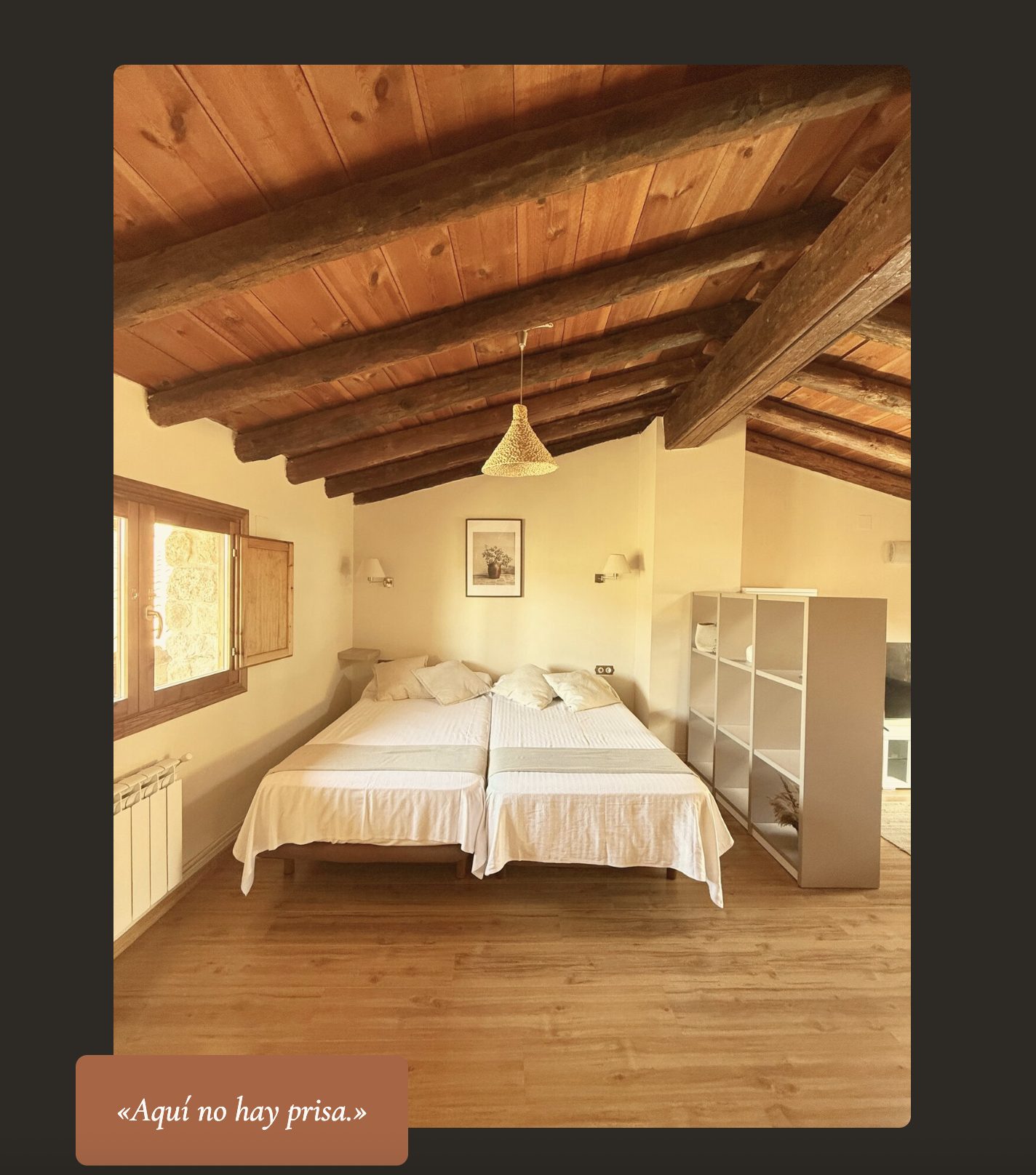 Dormitorio abuhardillado con vigas de madera en un apartamento de Apolonia