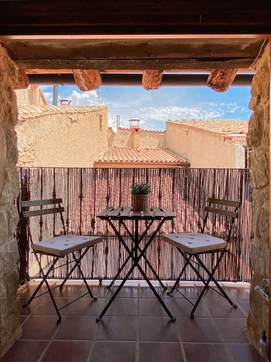 Terraza con mesa para dos y vistas a los tejados de La Fresneda